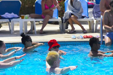 Sharm el-Sheikh, Mısır - 14 Mart 2018. Fitness kavramı, bir fitness sınıfı, bir grup insan aqua aerobik havuzu bir yaz günü açık havada üzerinde çalışmaktadır. Cyrene Grand otel konaklama