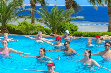 Sharm el-Sheikh, Mısır - 14 Mart 2018. Fitness kavramı, bir fitness sınıfı, bir grup insan aqua aerobik havuzu bir yaz günü açık havada üzerinde çalışmaktadır. Cyrene Grand otel konaklama