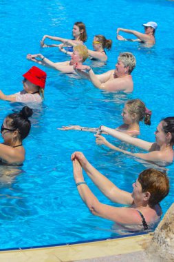 Sharm el-Sheikh, Mısır - 14 Mart 2018. Bir yaz günü açık havada üzerinde havuzunda aqua aerobik fitness kavramı, bir fitness sınıfı, bir grup insan çalışmaktadır.