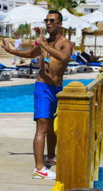 Sharm el-Sheikh, Mısır - 14 Mart 2018. Bir grup insan önünde bir fitness eğitmeni su alýþtýrmalarda nişanlı. bir yaz günü açık havada üzerinde. Cyrene Grand otel konaklama