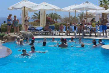 Sharm el-Sheikh, Mısır - 14 Mart 2018. Fitness kavramı, bir fitness sınıfı, bir grup insan aqua aerobik havuzu bir yaz günü açık havada üzerinde çalışmaktadır. Cyrene Grand otel konaklama