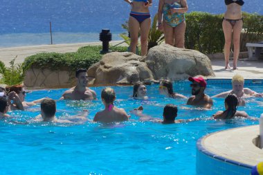 Sharm el-Sheikh, Mısır - 14 Mart 2018. Fitness kavramı, bir fitness sınıfı, bir grup insan aqua aerobik havuzu bir yaz günü açık havada üzerinde çalışmaktadır. Cyrene Grand otel konaklama