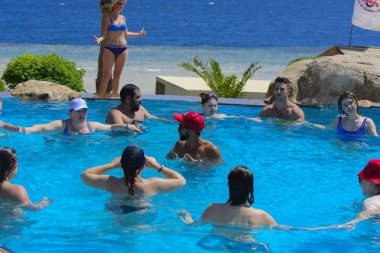 Sharm el-Sheikh, Mısır - 14 Mart 2018. Fitness kavramı, bir fitness sınıfı, bir grup insan aqua aerobik havuzu bir yaz günü açık havada üzerinde çalışmaktadır. Cyrene Grand otel konaklama
