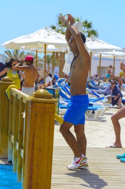 Sharm el-Sheikh, Mısır - 14 Mart 2018. Bir grup insan önünde bir fitness eğitmeni su alýþtýrmalarda nişanlı. bir yaz günü açık havada üzerinde. 