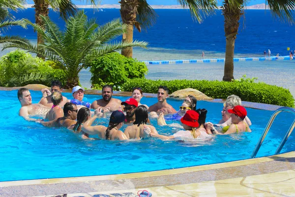Sharm el-Sheikh, Egypt - March 14, 2018. The fitness concept, a fitness class, a group of people is engaged in aqua aerobics in the pool on a summer day outdoors. — Stock Photo, Image