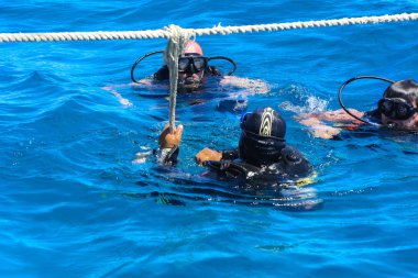 Dalgıçlar açık ve turkuaz Kızıldeniz daldırma güzel mercan ve renkli balık üzerinde. Öğretmen öğrenci suya daldırma kuralları öğretir.. 