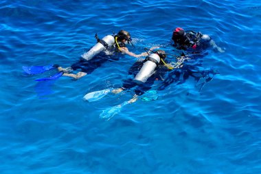 Dalgıçlar açık ve turkuaz Kızıldeniz daldırma güzel mercan ve renkli balık üzerinde. Öğretmen öğrenci suya daldırma kuralları öğretir.. 
