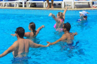 Sharm el-Sheikh, Mısır - 14 Mart 2018. Bir yaz günü açık havada üzerinde havuzunda aqua aerobik fitness kavramı, bir fitness sınıfı, bir grup insan çalışmaktadır. 