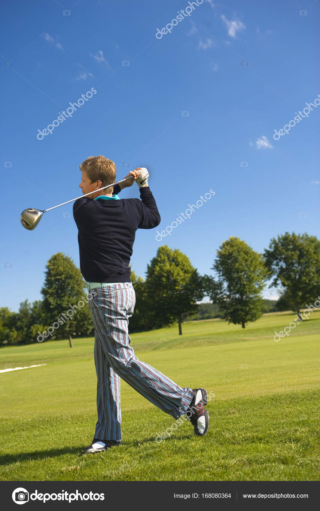 Side Profile Mid Adult Man Swinging Golf Club Stock Photo