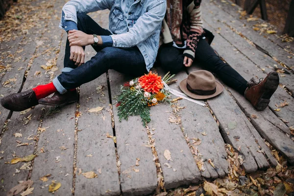 Man and woman sitting on wooden flooring — Stock Photo, Image