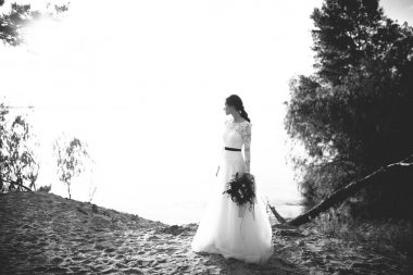 Gelin beyaz elbiseli kıyıda poz