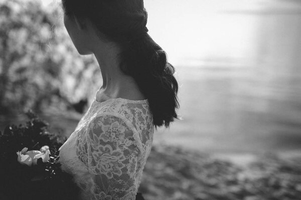 Cropped view of woman in wedding dress on shore