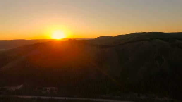 Flygfoto. Flyger över kullarna vid solnedgången. — Stockvideo