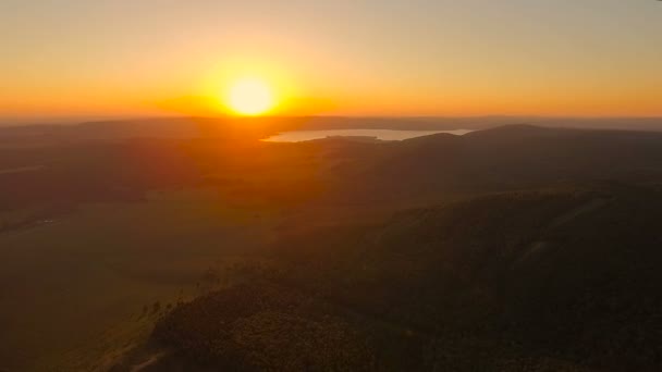 Flygfoto. Flyger över kullarna vid solnedgången. — Stockvideo