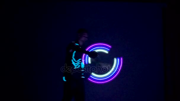 Man twists fiery circles on a light show. — Stock Video