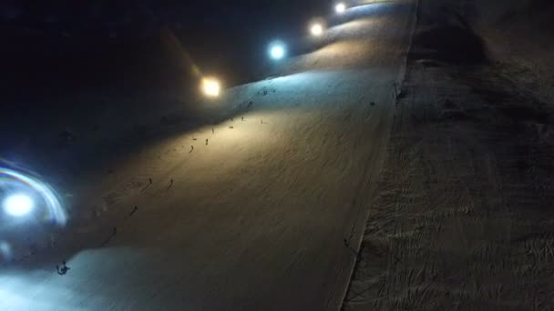 Nachtskifahren und Snowboarden in einem Skigebiet. — Stockvideo