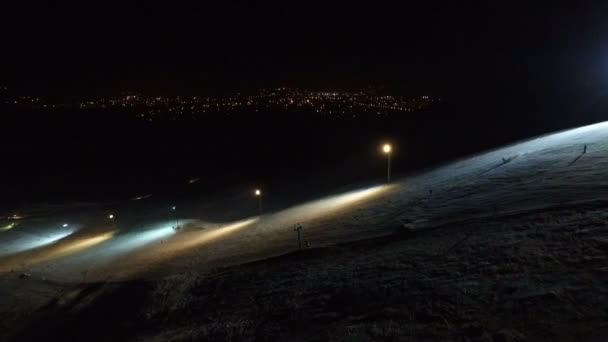 Pista de esquí en el fondo nocturno de la ciudad . — Vídeos de Stock