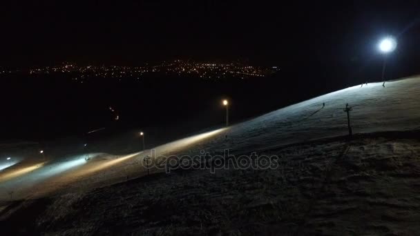 Pista de esquí en el fondo nocturno de la ciudad . — Vídeos de Stock