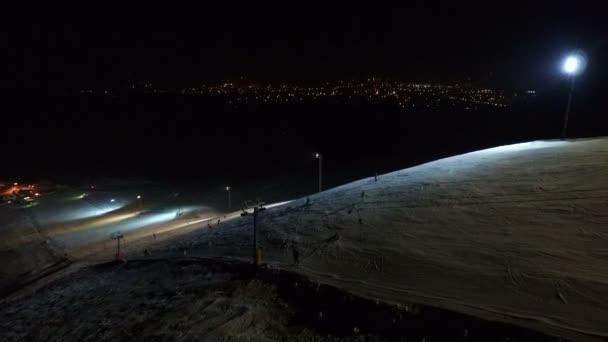 Pista de esquí en el fondo nocturno de la ciudad . — Vídeos de Stock