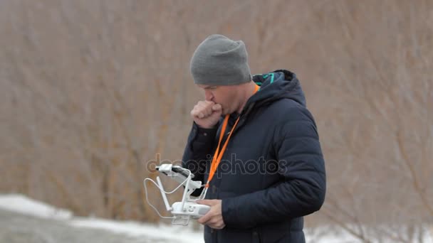 Un homme avec une télécommande se réchauffe les mains en respirant . — Video