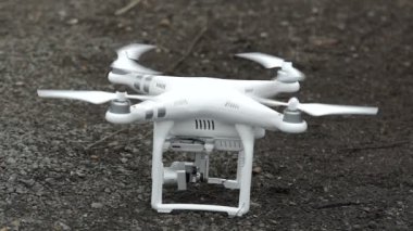 Zemin üzerinde bir dron duran pervaneler dönmeye başlayacak ve kapalı alır.