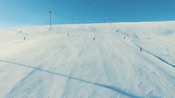 Varias personas montan esquí y snowboard por pendiente de nieve . — Vídeos de Stock