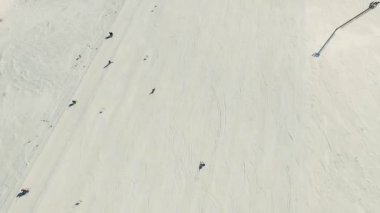 Birkaç kişi kayak ve snowboard binmek kar yamaç tarafından.