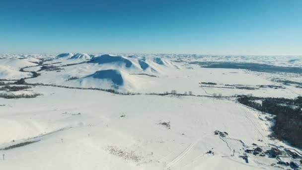 Tiro aéreo de montanhas e campos por estância de esqui . — Vídeo de Stock