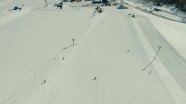 Birkaç kişi kayak ve snowboard binmek kar yamaç tarafından.