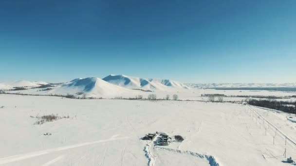 Aerial shot of mountains and fields by ski resort. — Stock Video