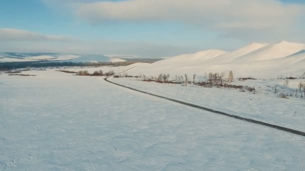 Δρόμος από το χιόνι πεδίο το σούρουπο. — Αρχείο Βίντεο
