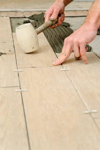Lavoratore mettendo piastrelle sul pavimento . — Foto Stock