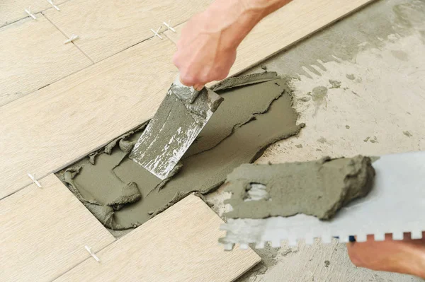 Trabajador poniendo azulejos en el suelo . — Foto de Stock