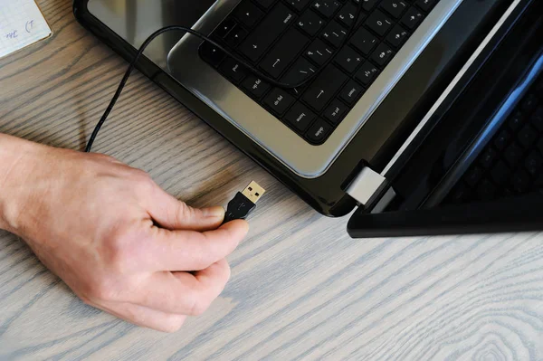 De hand van de mens wordt aangesloten op de USB-kabel. — Stockfoto