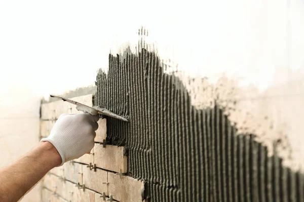 Installing the tiles on the wall.