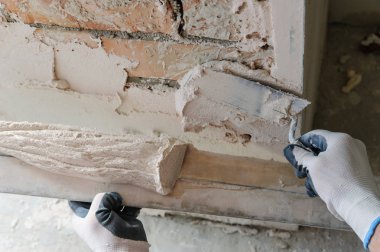 Çalışan bir alçı plaste koyuyor.