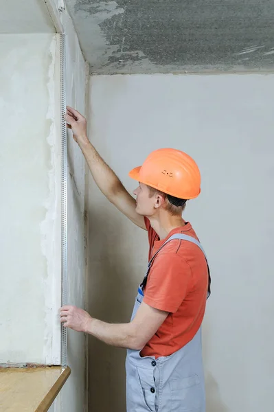 Werknemer is het installeren van een geperforeerde aluminium hoek. — Stockfoto