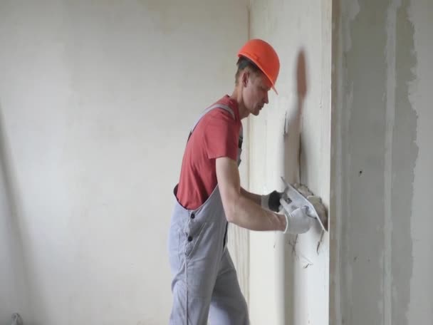 Trabajador está poniendo un yeso de yeso en una pared . — Vídeos de Stock