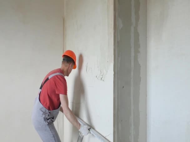 Trabajador está poniendo un yeso de yeso en una pared . — Vídeo de stock