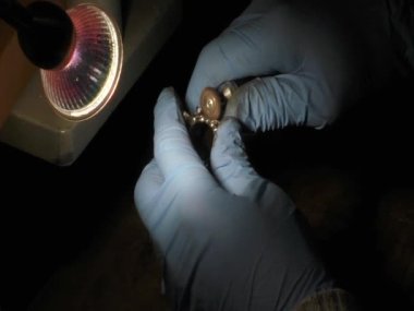 Kuyumcu bir cilalama makinesi kullanıyor.