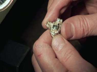 Adam bir yüzüğü tutuyor.