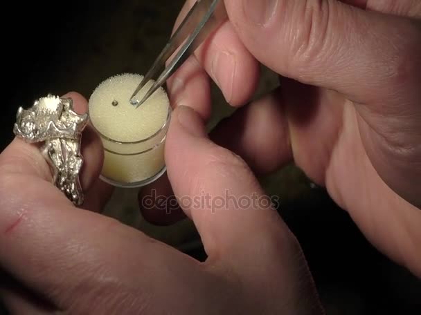 Joalheiro está inserindo e fixando uma jóia . — Vídeo de Stock