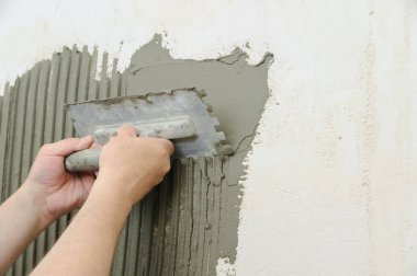 Bir yapıştırıcı Tilers ellerini koyarak.