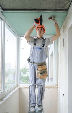 İşçi drywall tamir ediyor.