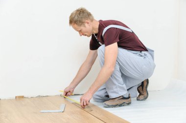 Installation of a laminate floorboard. clipart