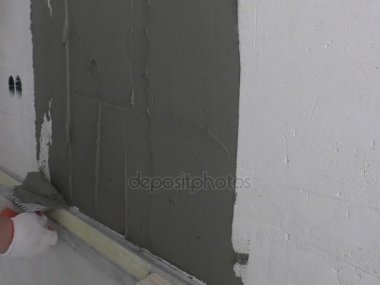 İşçinin ellerini fayans yapıştırıcı koyarak.
