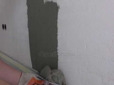 İşçinin ellerini fayans yapıştırıcı koyarak.