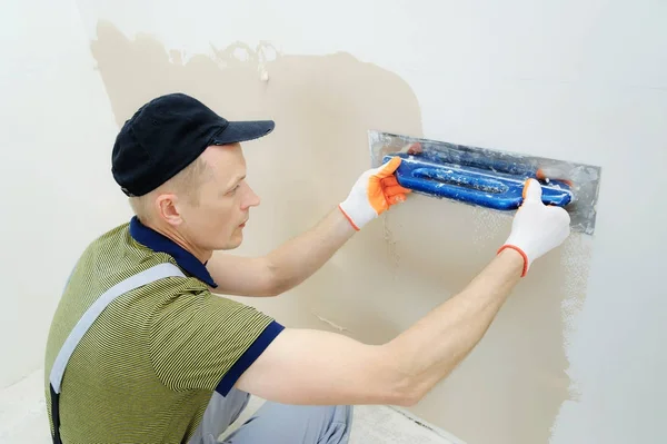 Ein Arbeiter verputzt eine Wand. — Stockfoto