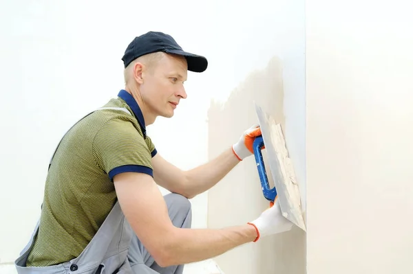 Un trabajador está enyesando una pared . — Foto de Stock