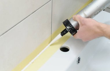 Bir adam silikon dolgu macunu giyiyor.